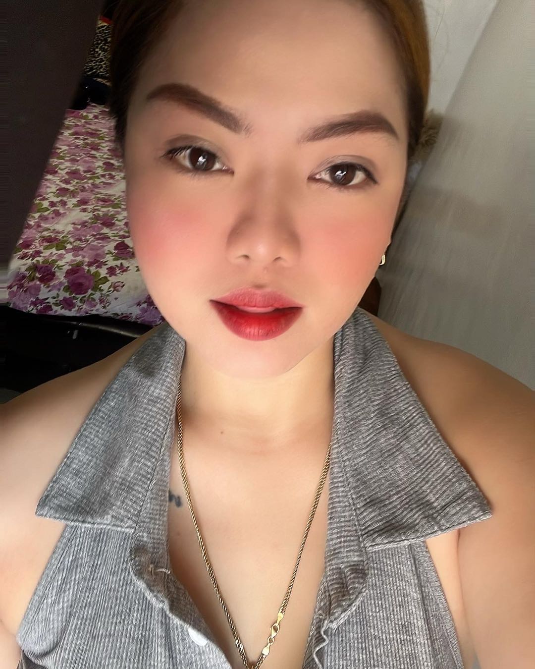 A woman from the Philippines in a silver halter top with red lipstick